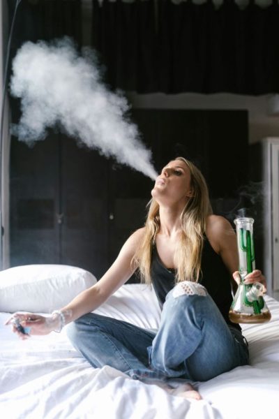 girl smoking a bong in bed
